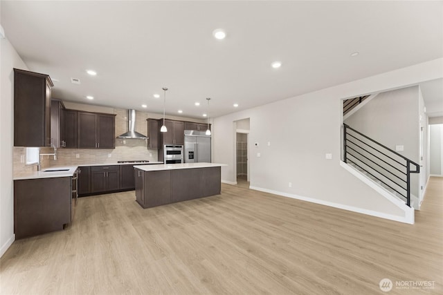 10532 135th Ave NE Unit 32, Kirkland, WA 98033 - kitchen with wall chimney range hood, a sink, appliances with stainless steel finishes, a center island, and dark brown cabinetry