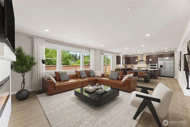 10532 135th Ave NE Unit 32, Kirkland, WA 98033 - living area with light wood finished floors, recessed lighting, a glass covered fireplace, and baseboards