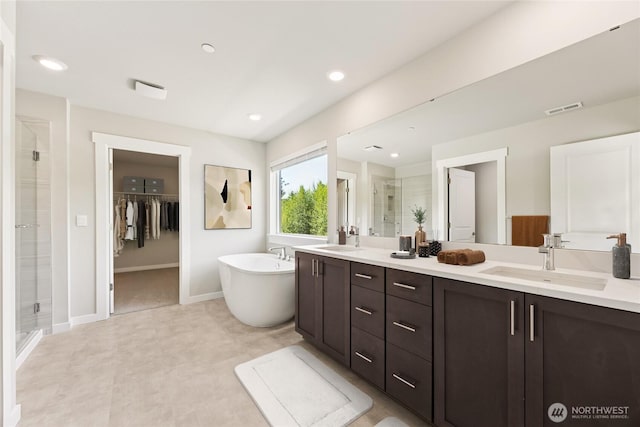 10532 135th Ave NE Unit 32, Kirkland, WA 98033 - bathroom with a stall shower, double vanity, a soaking tub, a walk in closet, and baseboards