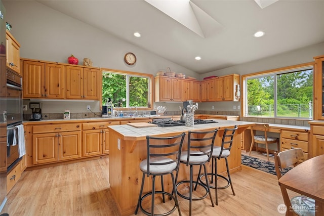 23405 Jordan Rd, Arlington, WA 98223 - kitchen featuring light wood-type flooring, a kitchen island, stainless steel gas stovetop, tile countertops, and recessed lighting
