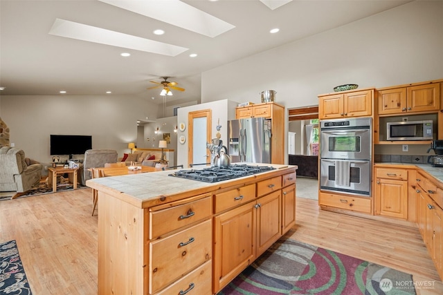 23405 Jordan Rd, Arlington, WA 98223 - kitchen with appliances with stainless steel finishes, tile countertops, a skylight, vaulted ceiling, and light wood-style flooring