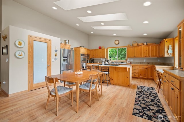 23405 Jordan Rd, Arlington, WA 98223 - kitchen with appliances with stainless steel finishes, a skylight, vaulted ceiling, light wood-type flooring, and a center island