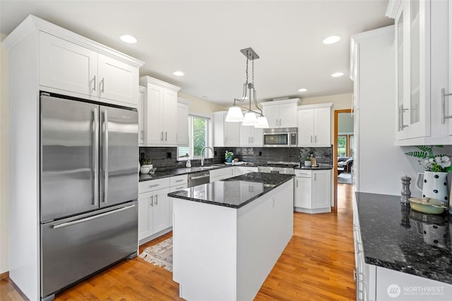 4239 Northridge Way, Bellingham, WA 98226 - kitchen featuring appliances with stainless steel finishes, a sink, white cabinetry, light wood-style floors, and backsplash