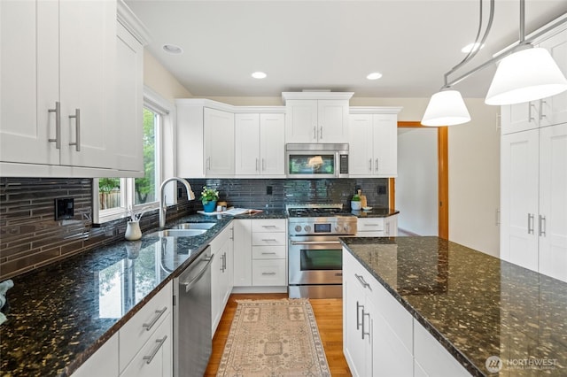4239 Northridge Way, Bellingham, WA 98226 - kitchen featuring appliances with stainless steel finishes, a sink, light wood finished floors, white cabinetry, and backsplash