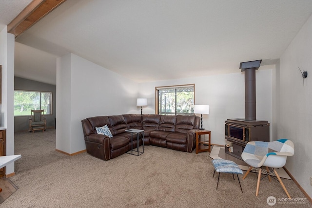 18226 Road B NW, Ephrata, WA 98823 - living area with a wood stove, light colored carpet, lofted ceiling, and baseboards