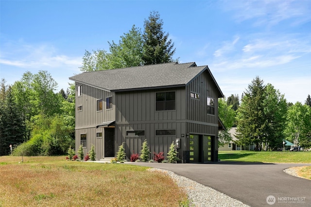 141 Pebble Beach Dr, Cle Elum, WA 98922 - modern inspired farmhouse featuring board and batten siding, roof with shingles, asphalt driveway, a front yard, and a garage