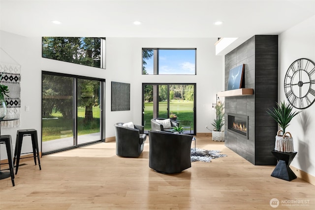 141 Pebble Beach Dr, Cle Elum, WA 98922 - living area with a tile fireplace, light wood-type flooring, recessed lighting, and a high ceiling