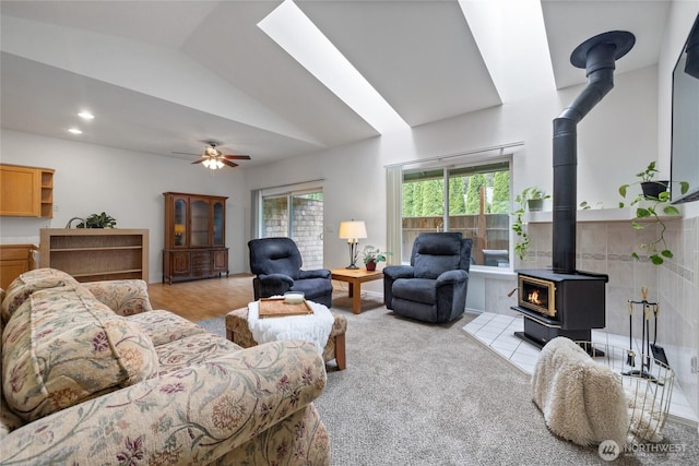 14126 95th Ave NW, Gig Harbor, WA 98329 - living area featuring a wood stove, plenty of natural light, vaulted ceiling, ceiling fan, and light colored carpet
