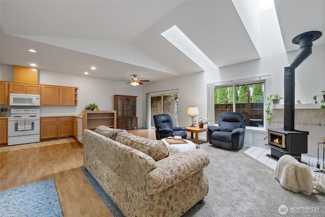 14126 95th Ave NW, Gig Harbor, WA 98329 - living area featuring a wood stove, ceiling fan, light wood finished floors, recessed lighting, and high vaulted ceiling