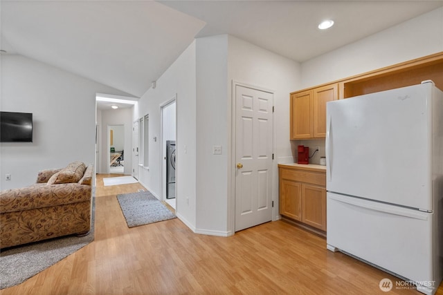 14126 95th Ave NW, Gig Harbor, WA 98329 - kitchen with freestanding refrigerator, light wood finished floors, open floor plan, washer / dryer, and vaulted ceiling