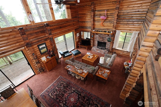 215 Marine Dr, Blakely Island, WA 98222 - living room featuring log walls, plenty of natural light, a ceiling fan, carpet floors, and a towering ceiling