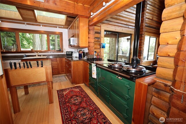 215 Marine Dr, Blakely Island, WA 98222 - kitchen featuring a sink, rustic walls, white microwave, healthy amount of natural light, and light wood-style flooring