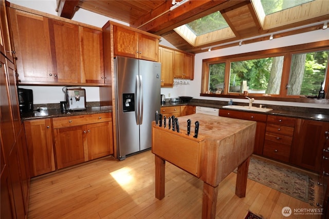 215 Marine Dr, Blakely Island, WA 98222 - kitchen with stainless steel fridge, a sink, a skylight, brown cabinets, and wood ceiling