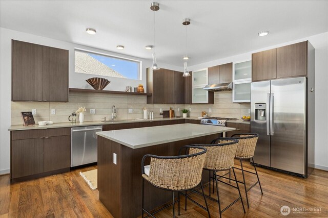 8838 Interlake Ave N, Seattle, WA 98103 - kitchen with appliances with stainless steel finishes, a kitchen bar, a sink, and backsplash