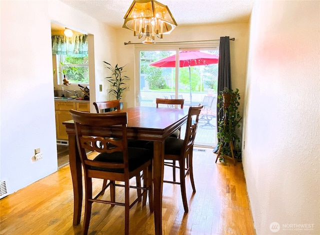 31405 10th Ave S, Federal Way, WA 98003 - dining room featuring light wood-type flooring, a chandelier, and a textured ceiling