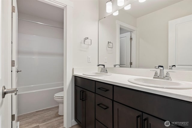 11210 79th Avenue Ct SW, Lakewood, WA 98498 - full bathroom with double vanity, toilet, wood finished floors, and shower / tub combination