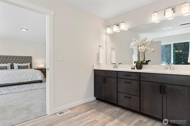 11210 79th Avenue Ct SW, Lakewood, WA 98498 - full bathroom featuring wood finished floors, double vanity, ensuite bath, and baseboards