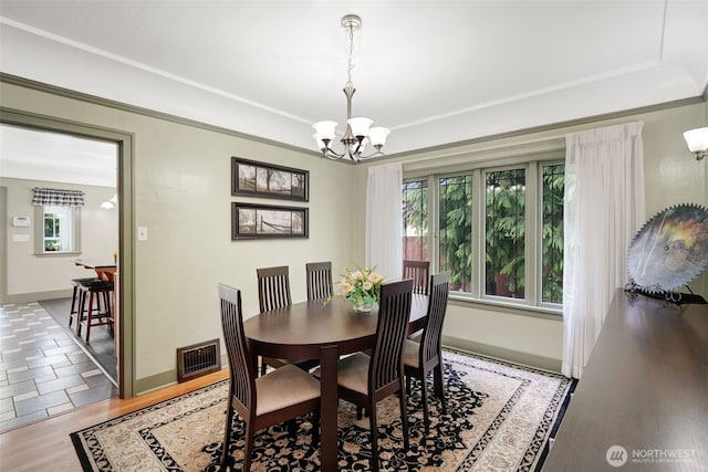 181 N 2nd St, Morton, WA 98356 - dining space with a chandelier, light wood-type flooring, a raised ceiling, and baseboards