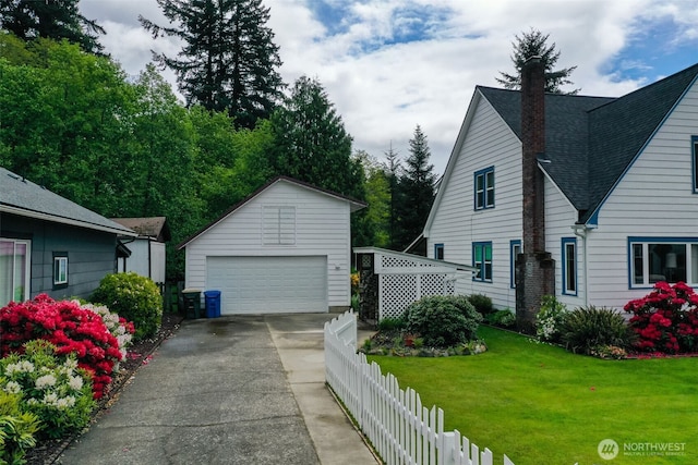 181 N 2nd St, Morton, WA 98356 - view of side of home with a detached garage, an outbuilding, a chimney, and roof with shingles