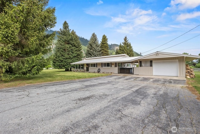 7938 E Leavenworth Rd, Leavenworth, WA 98826 - ranch-style home with a garage, asphalt driveway, and a front lawn