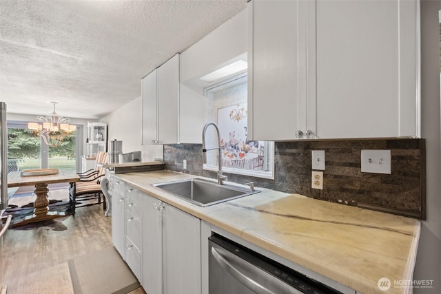 7938 E Leavenworth Rd, Leavenworth, WA 98826 - kitchen featuring a sink, dishwasher, a textured ceiling, white cabinetry, and a chandelier