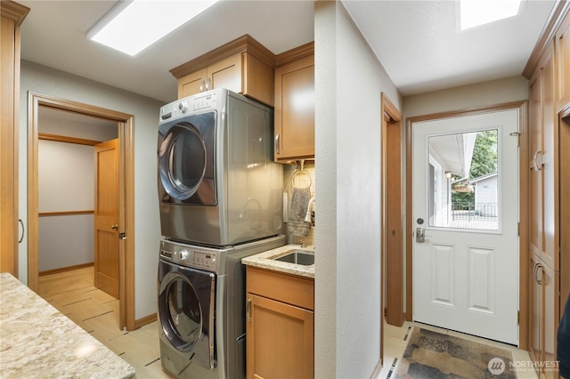 28118 163rd St E, Wilkeson, WA 98396 - washroom featuring stacked washing machine and dryer, cabinet space, and baseboards