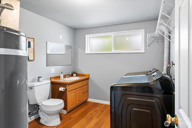 22606 87th Ave W, Edmonds, WA 98026 - bathroom featuring washer / clothes dryer, wood finished floors, toilet, vanity, and baseboards