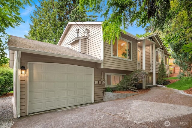 3816 NE 110th St, Seattle, WA 98125 - view of front of house with concrete driveway, an attached garage, and a shingled roof