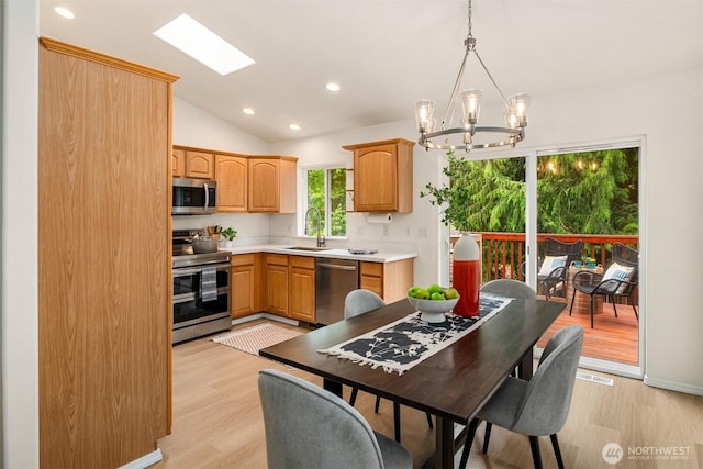 3816 NE 110th St, Seattle, WA 98125 - kitchen featuring appliances with stainless steel finishes, a chandelier, light wood-style floors, vaulted ceiling, and light countertops