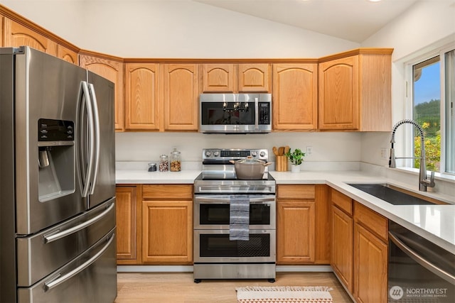 3816 NE 110th St, Seattle, WA 98125 - kitchen featuring appliances with stainless steel finishes, light wood-style flooring, vaulted ceiling, and light countertops