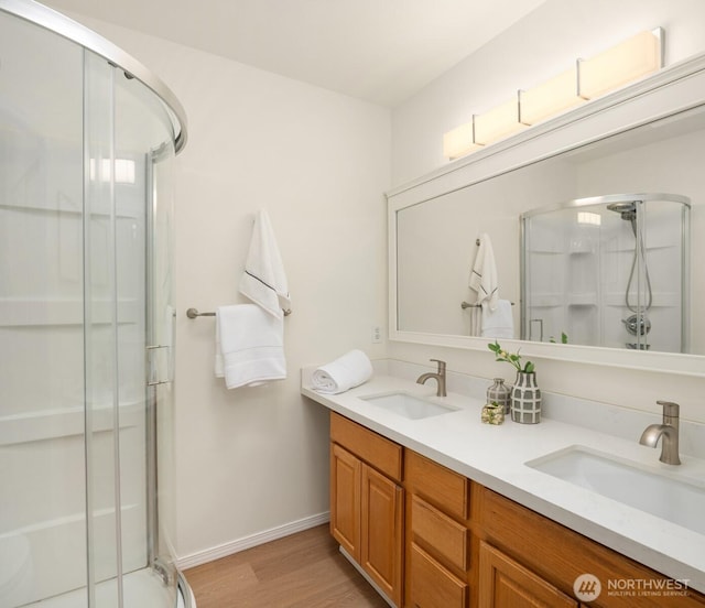 3816 NE 110th St, Seattle, WA 98125 - full bathroom with a shower stall, double vanity, and wood finished floors