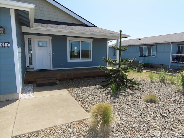 417 Riviera St SW, Ocean Shores, WA 98569 - property entrance featuring a shingled roof and covered porch