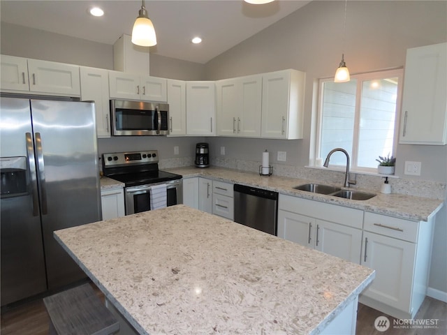 417 Riviera St SW, Ocean Shores, WA 98569 - kitchen featuring appliances with stainless steel finishes, a sink, vaulted ceiling, white cabinetry, and a kitchen island
