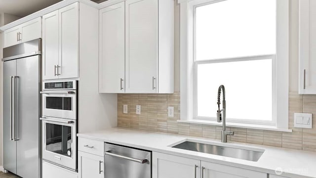 13473 NE 105th Ct Unit 12, Kirkland, WA 98033 - kitchen with appliances with stainless steel finishes, a sink, decorative backsplash, light countertops, and white cabinetry