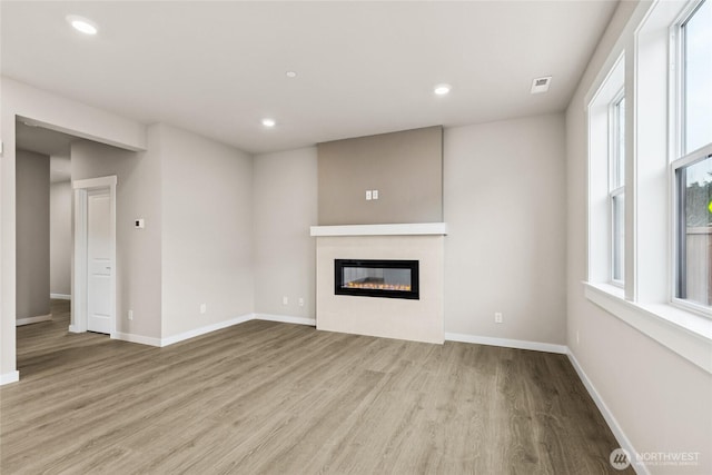13473 NE 105th Ct Unit 12, Kirkland, WA 98033 - unfurnished living room with wood finished floors, a glass covered fireplace, baseboards, and recessed lighting