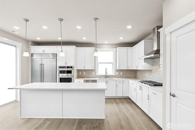 13473 NE 105th Ct Unit 12, Kirkland, WA 98033 - kitchen with wall chimney exhaust hood, stainless steel appliances, a sink, a kitchen island, and light countertops