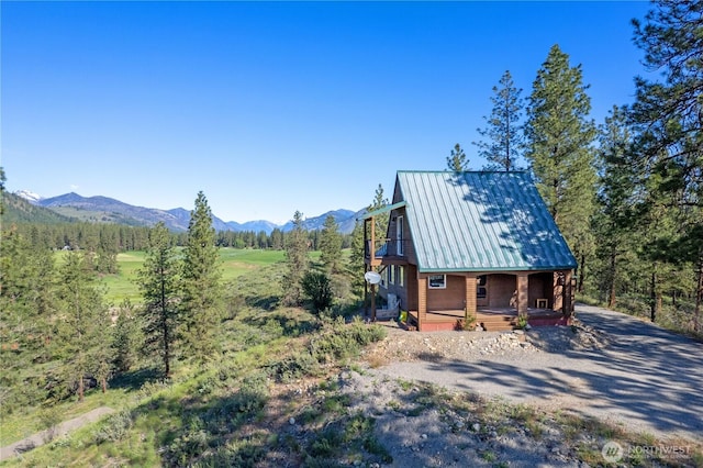 11 Appaloosa Rd, Winthrop, WA 98862 - view of home's exterior featuring a porch, a mountain view, metal roof, a standing seam roof, and driveway
