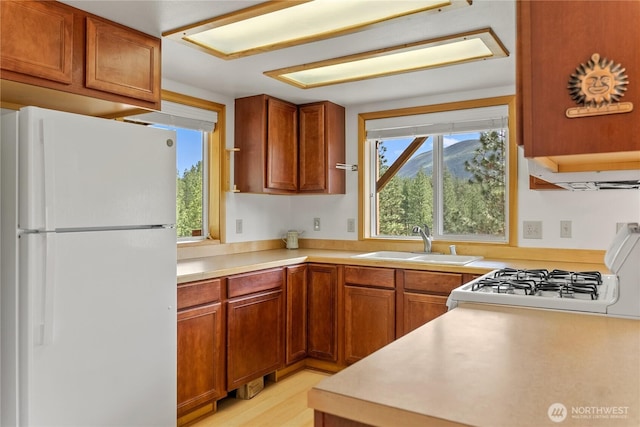 11 Appaloosa Rd, Winthrop, WA 98862 - kitchen featuring freestanding refrigerator, a sink, range, light countertops, and brown cabinets