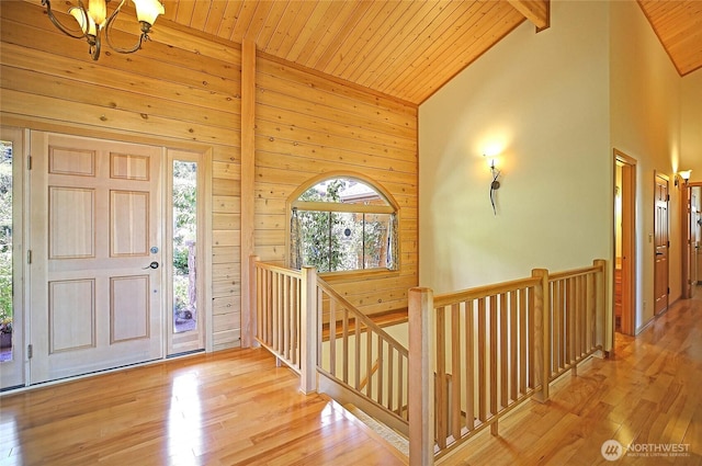 1051 Lightning Way, Camano Island, WA 98282 - foyer entrance featuring wooden ceiling with exposed beams, wood finished floors, wood walls, a chandelier, and high vaulted ceiling