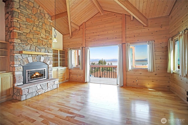 1051 Lightning Way, Camano Island, WA 98282 - unfurnished living room featuring wood-type flooring, wood ceiling with exposed beams, healthy amount of natural light, a fireplace, and wood walls