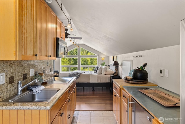 1751 Stone Ridge Dr, Cle Elum, WA 98922 - kitchen with stainless steel microwave, vaulted ceiling, a sink, electric cooktop, and tasteful backsplash