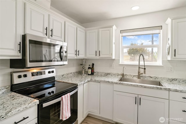 1123 Mather Dr, Moses Lake, WA 98837 - kitchen with appliances with stainless steel finishes, a sink, white cabinets, tasteful backsplash, and recessed lighting