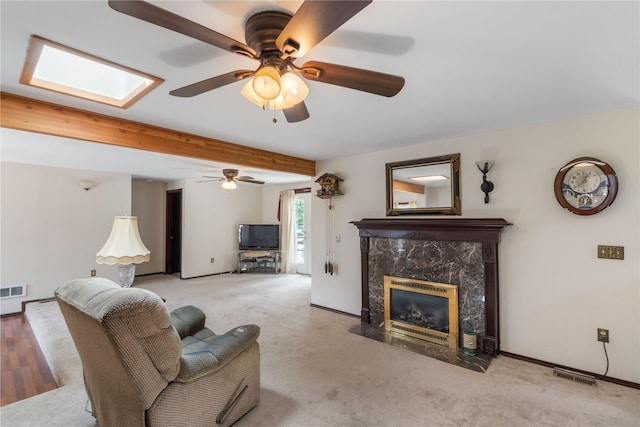 21410 161st Ave E, Graham, WA 98338 - living room with a high end fireplace, ceiling fan, beamed ceiling, a skylight, and carpet flooring