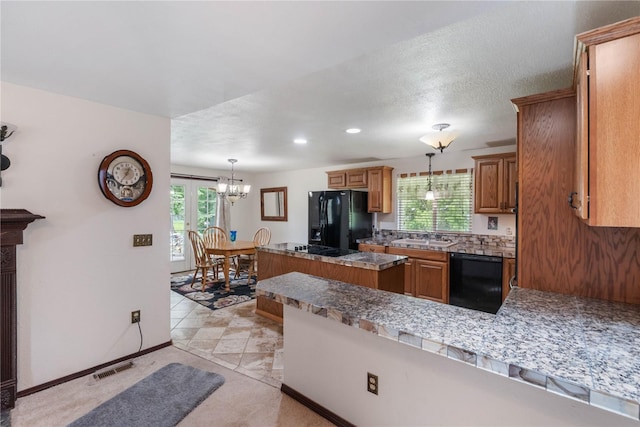21410 161st Ave E, Graham, WA 98338 - kitchen with black appliances, a chandelier, brown cabinetry, a peninsula, and a sink