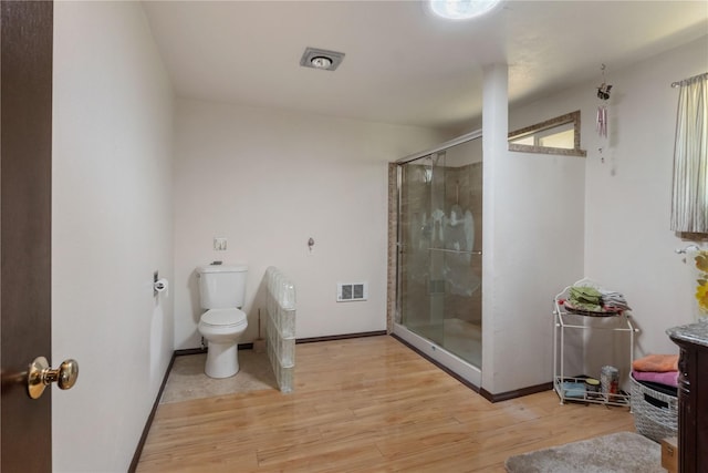 21410 161st Ave E, Graham, WA 98338 - bathroom featuring toilet, a stall shower, wood finished floors, and baseboards