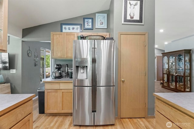 17943 Clear Lake Blvd SE, Yelm, WA 98597 - kitchen featuring stainless steel refrigerator with ice dispenser, light brown cabinetry, light countertops, light wood-type flooring, and vaulted ceiling