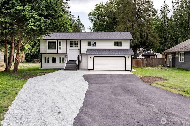 8302 319th St NW, Stanwood, WA 98292 - bi-level home featuring asphalt driveway, a garage, and roof with shingles