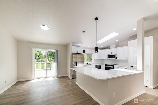 8302 319th St NW, Stanwood, WA 98292 - kitchen with stainless steel appliances, a sink, white cabinets, baseboards, and lofted ceiling
