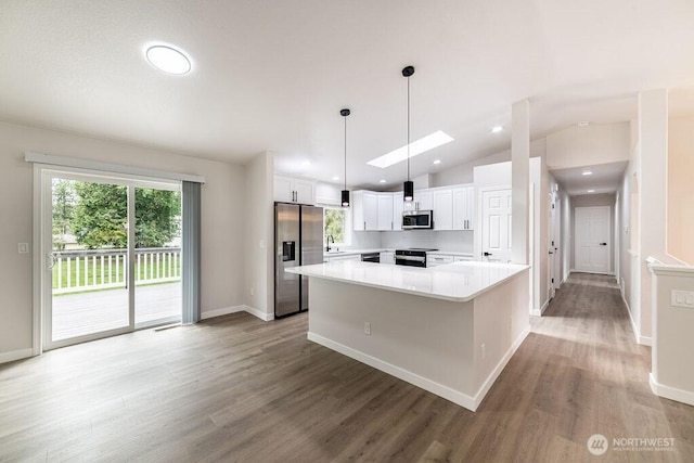 8302 319th St NW, Stanwood, WA 98292 - kitchen with appliances with stainless steel finishes, a center island, light wood-style flooring, white cabinetry, and light countertops