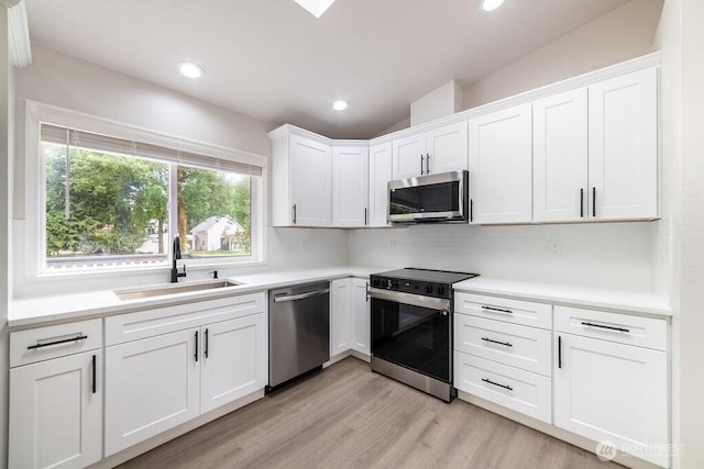 8302 319th St NW, Stanwood, WA 98292 - kitchen with appliances with stainless steel finishes, a sink, decorative backsplash, white cabinets, and light countertops